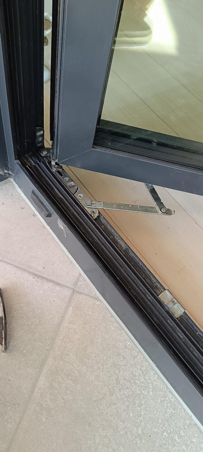 Detail kovania balkónových dverí počas servisného zásahu